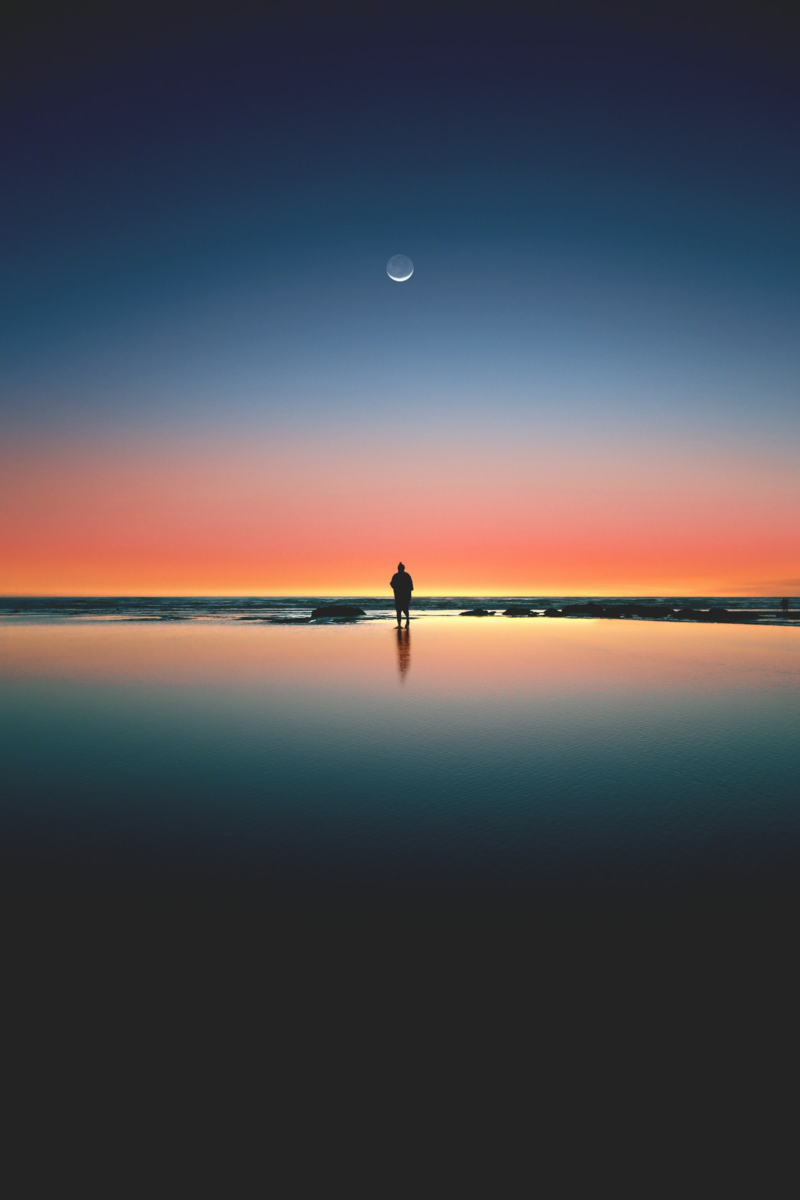 Person sitting alone at sunset while recovering from a breakup