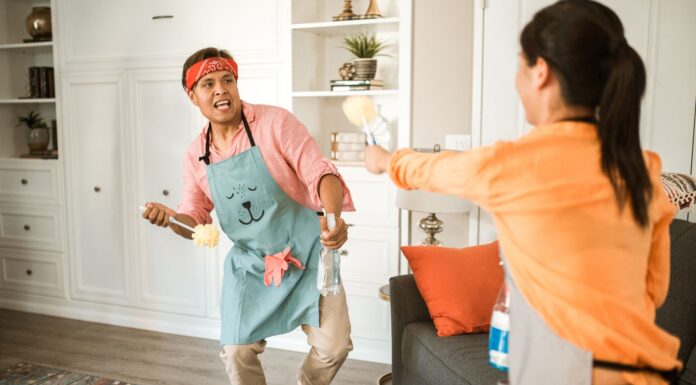 Couple cleaning their home together while sharing household chores