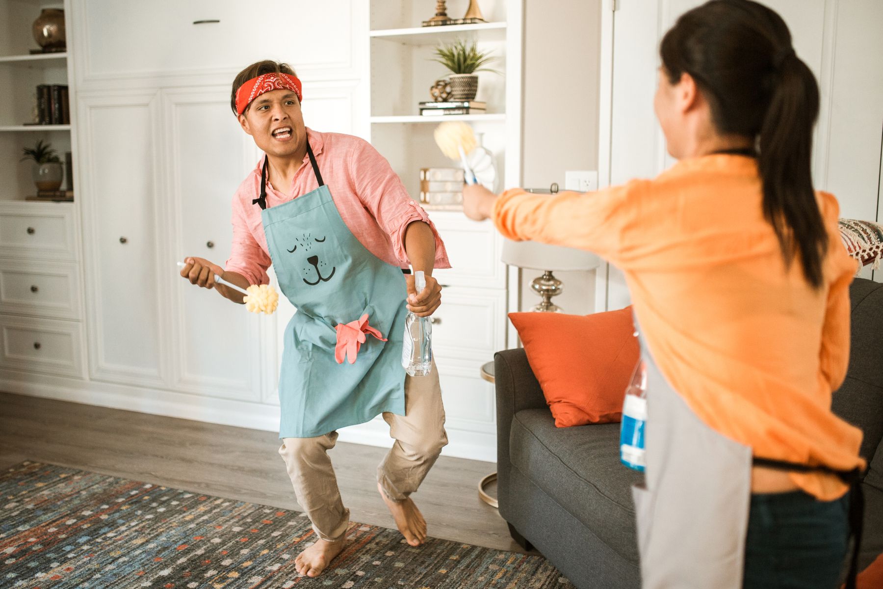 Couple cleaning their home together while sharing household chores
