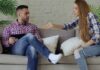 Emotional Neglect in a Relationship: Signs, Impact, and What to Do Next Couple sitting on a couch during a difficult conversation about emotional disconnection