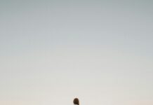 Person reflecting by the shoreline after a relationship ends