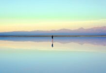 Person reflecting near the water during the first month after a breakup