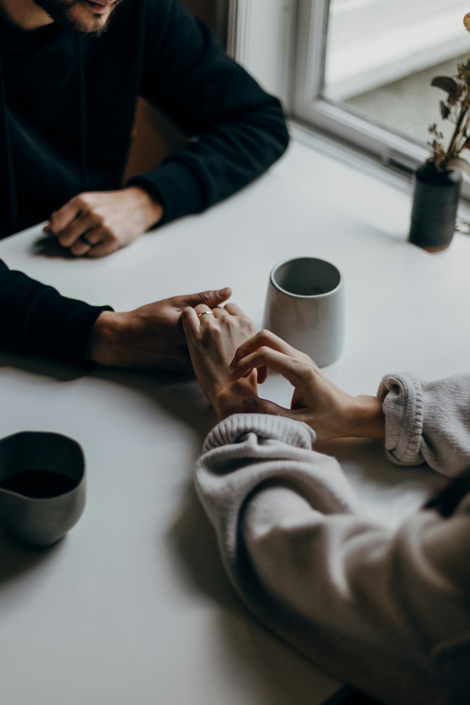 Partners holding hands during a calm conversation about jealousy