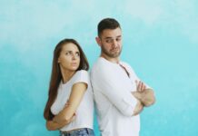 Couple standing back to back after a tense disagreement about fairness in the relationship