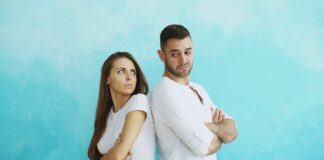 Couple standing back to back after a tense disagreement about fairness in the relationship