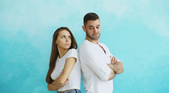 Couple standing back to back after a tense disagreement about fairness in the relationship