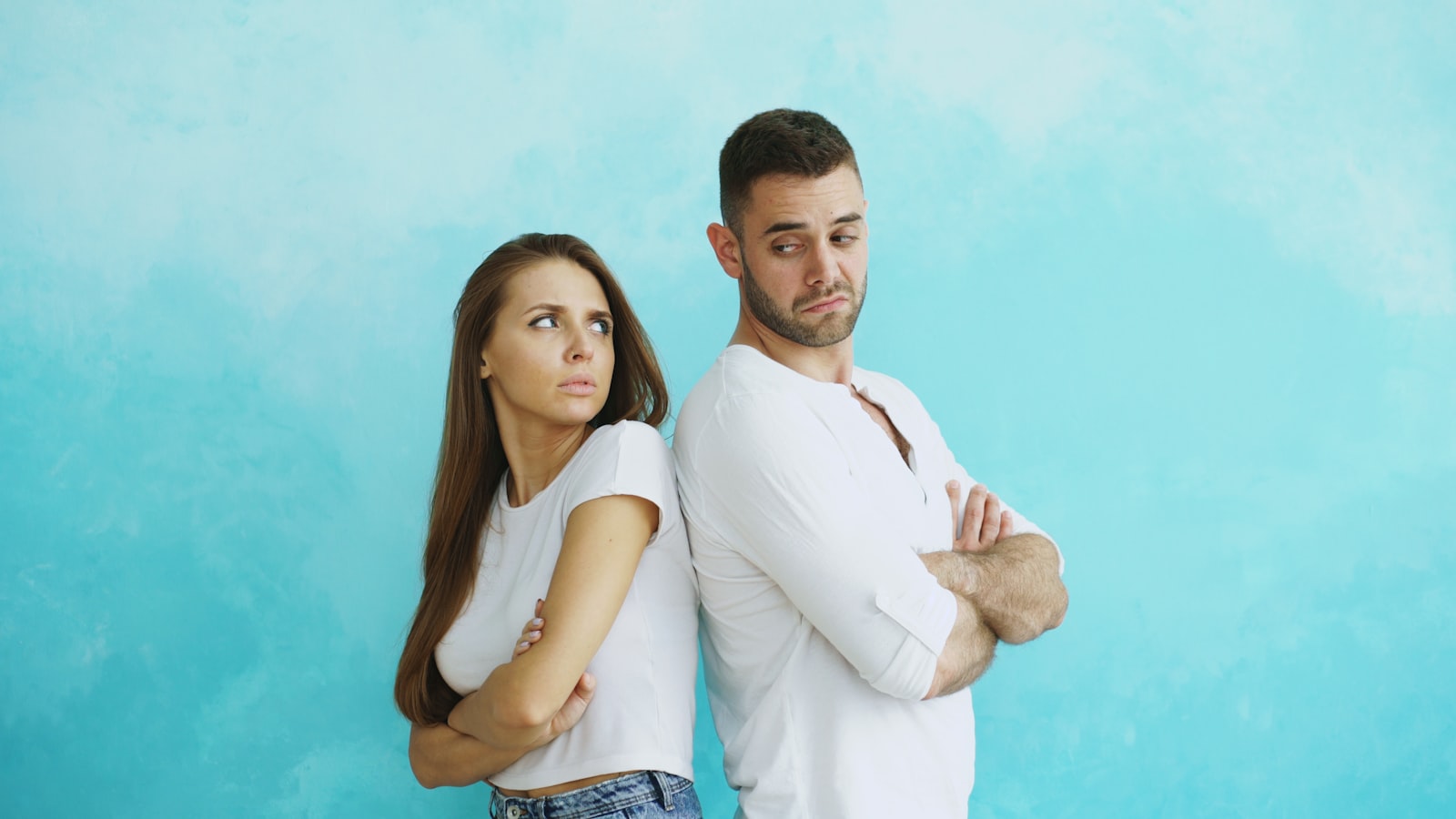 Couple standing back to back after a tense disagreement about fairness in the relationship