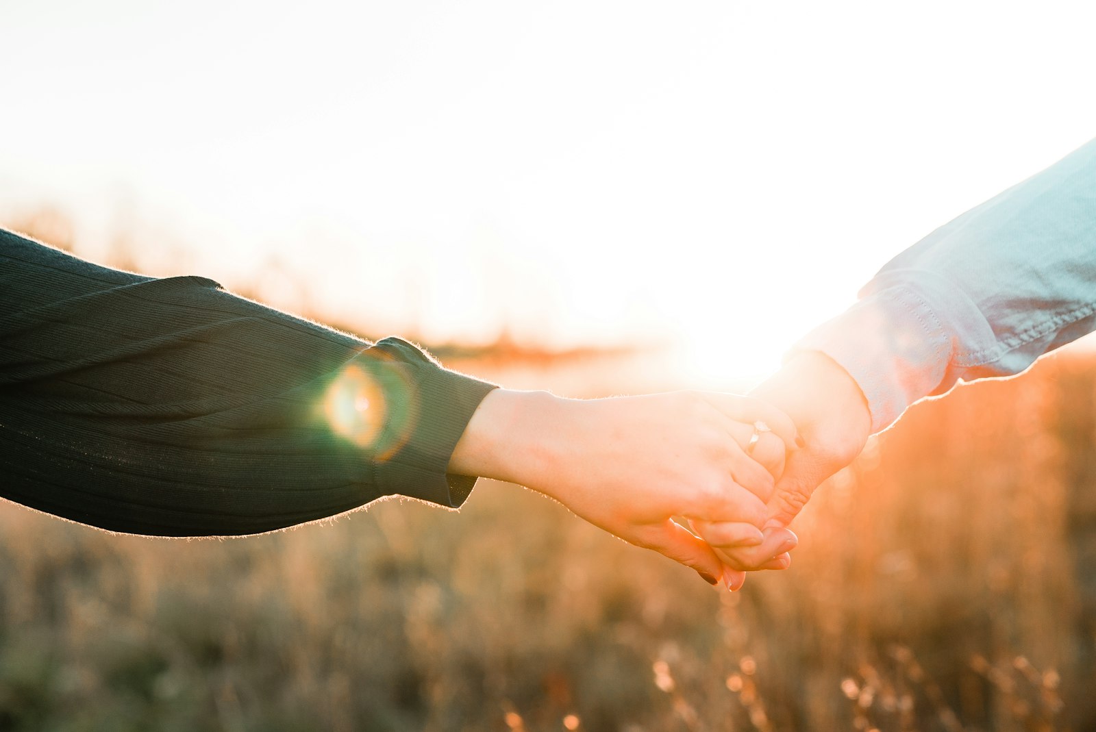 Two people holding hands as they work toward repair after resentment and scorekeeping in the relationship