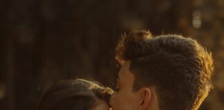 Partner showing quiet affection through a kiss on the forehead