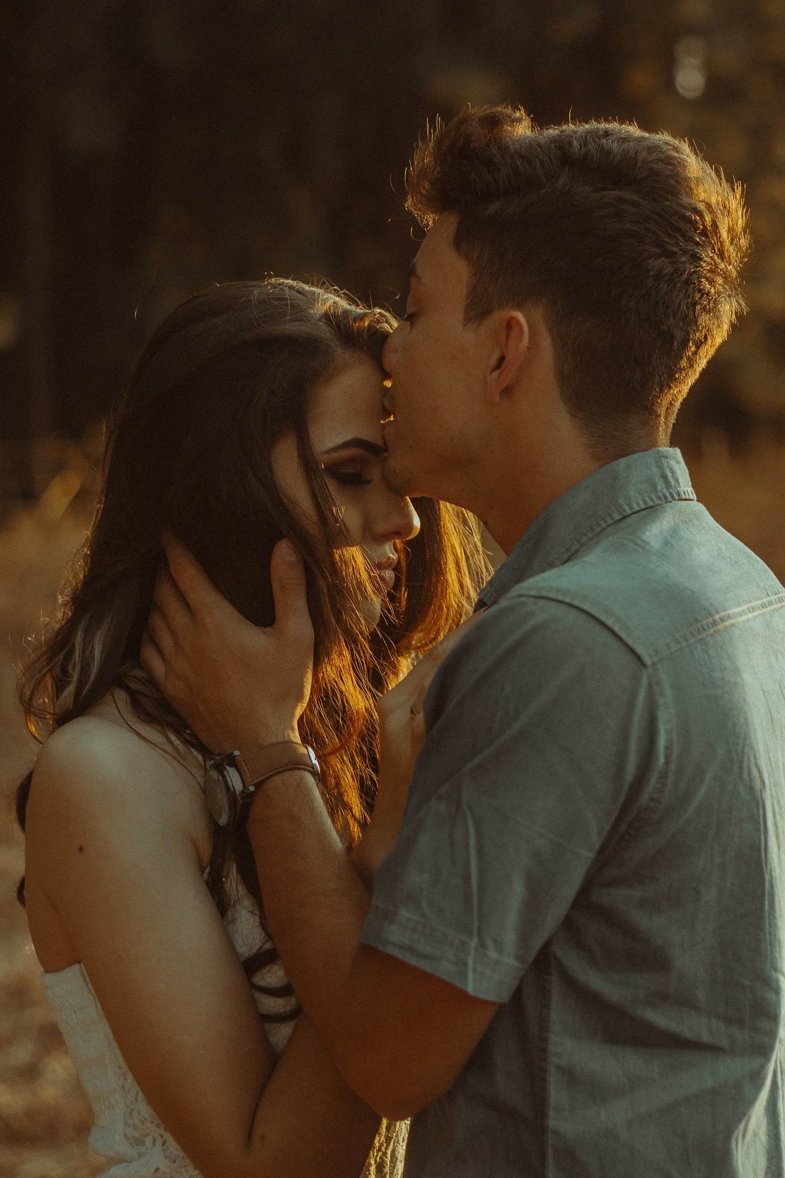 Partner showing quiet affection through a kiss on the forehead
