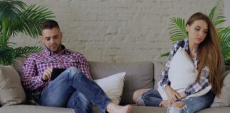 Couple sitting apart on a sofa during a pursuer-distancer conflict