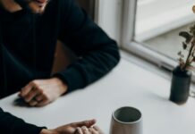 How to Rebuild Trust After Lying in a Relationship Couple holding hands across a table while rebuilding trust after a hard conversation