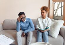 How to Stop Overthinking in a Relationship Without Constant Reassurance Couple sitting on a couch having a tense conversation while working through relationship anxiety