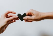 Starting a New Relationship: What to Discuss Before Getting Serious Two people holding a paper heart while starting a new relationship