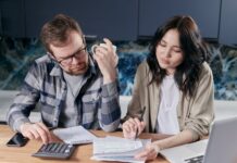 Couple discussing joint and separate bank accounts at home