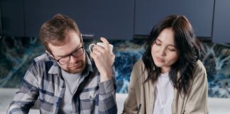 Couple discussing joint and separate bank accounts at home