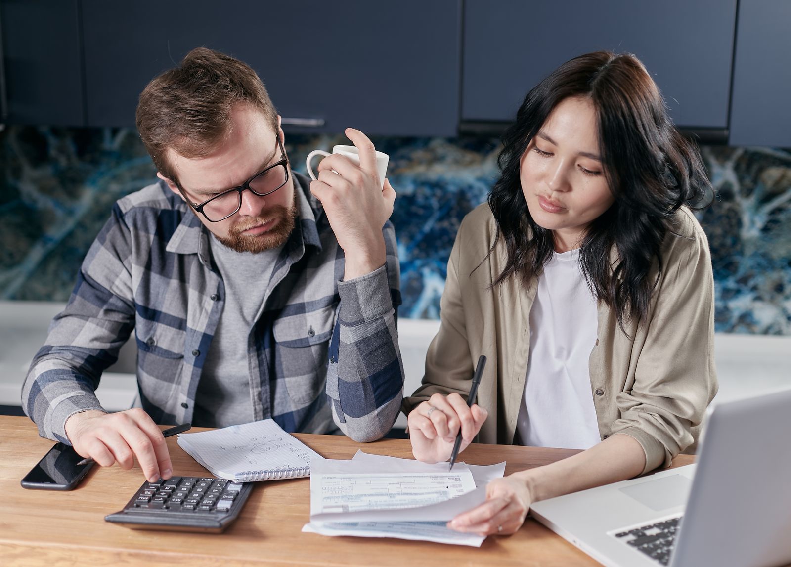 Couple discussing joint and separate bank accounts at home