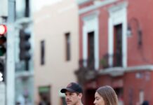 Couple holding hands while walking together in public