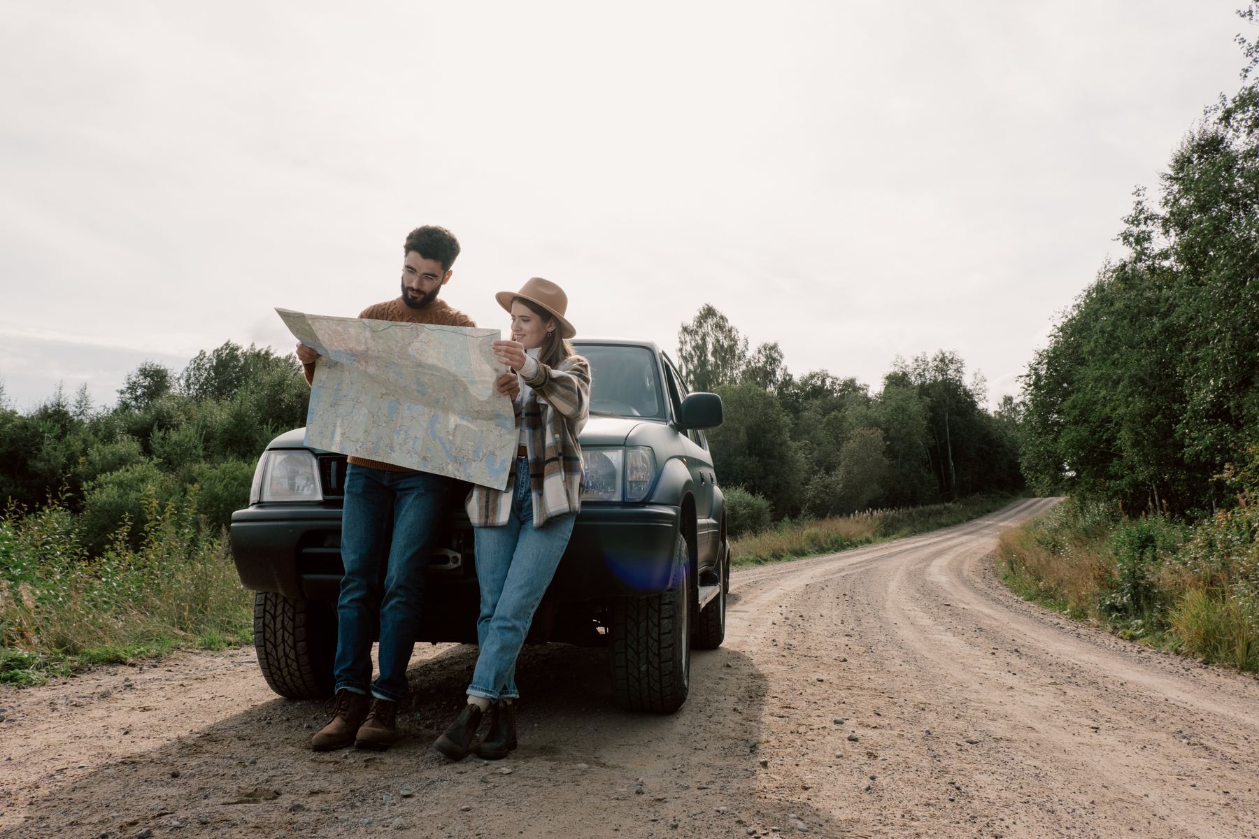 Couple navigating together with a map during a road trip