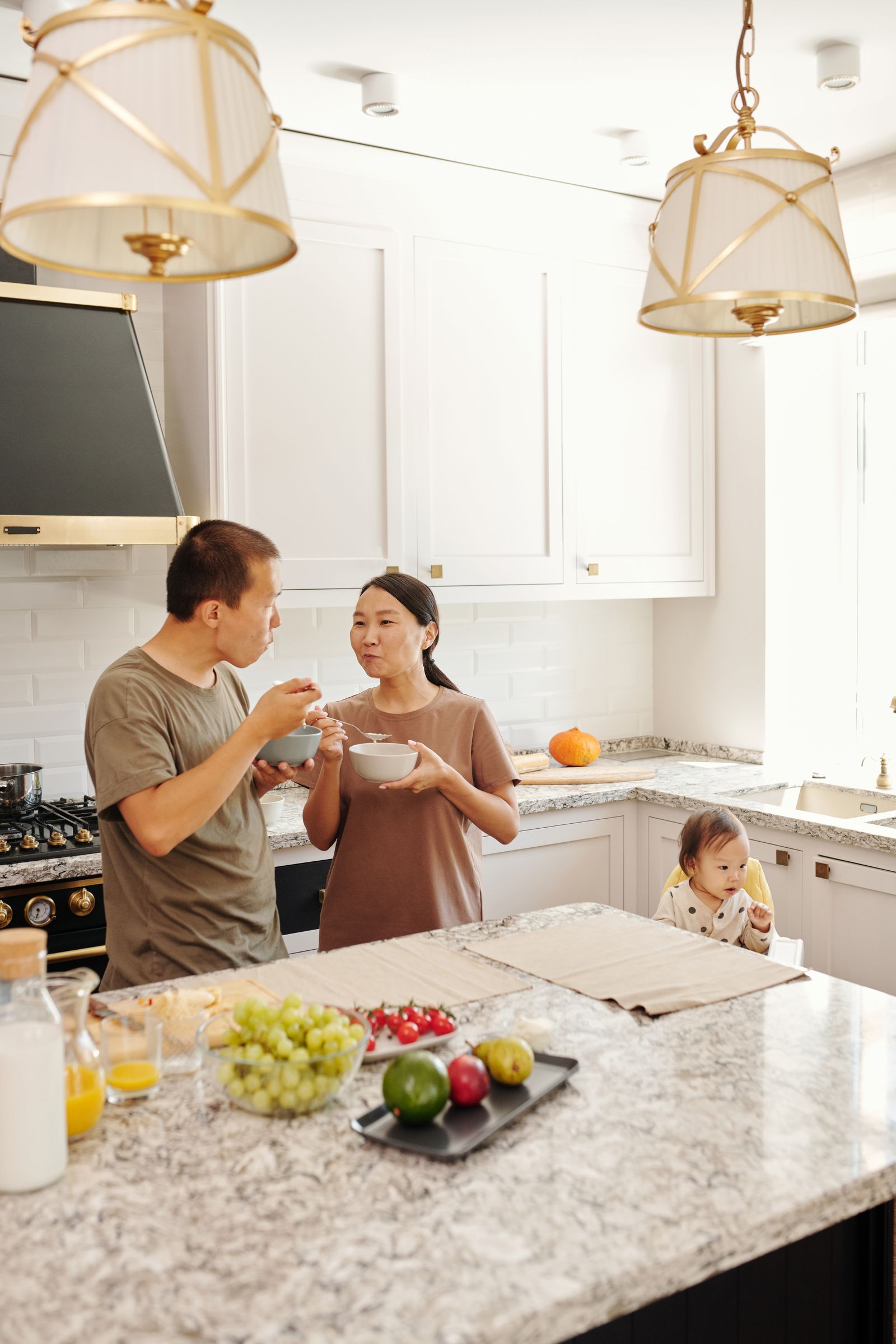 Parents having a quiet conversation in the kitchen while caring for their baby