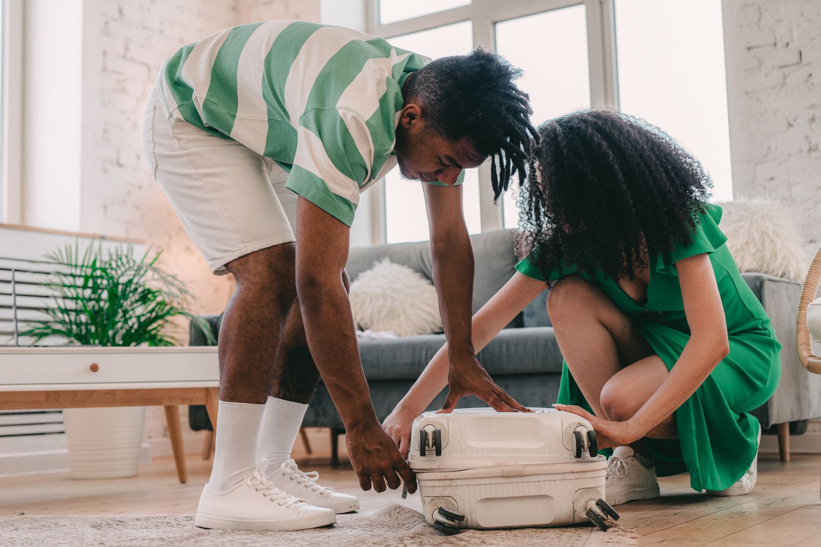 Couple packing a suitcase and planning together before a work trip