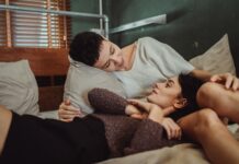 Couple talking in bed while working around different sleep schedules