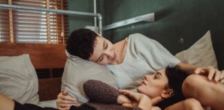 Couple talking in bed while working around different sleep schedules