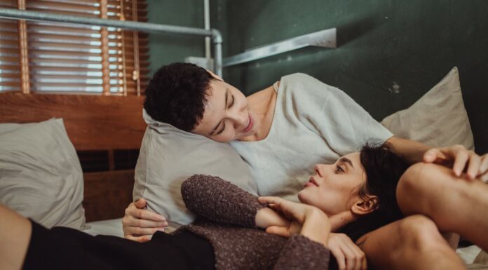 Couple talking in bed while working around different sleep schedules