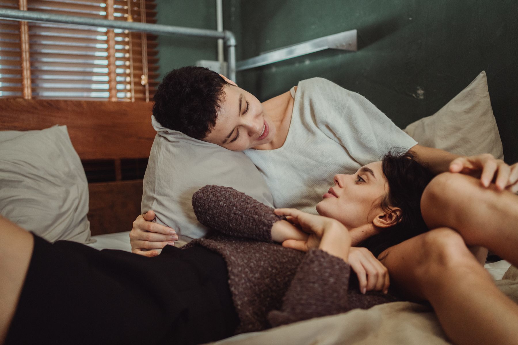 Couple talking in bed while working around different sleep schedules