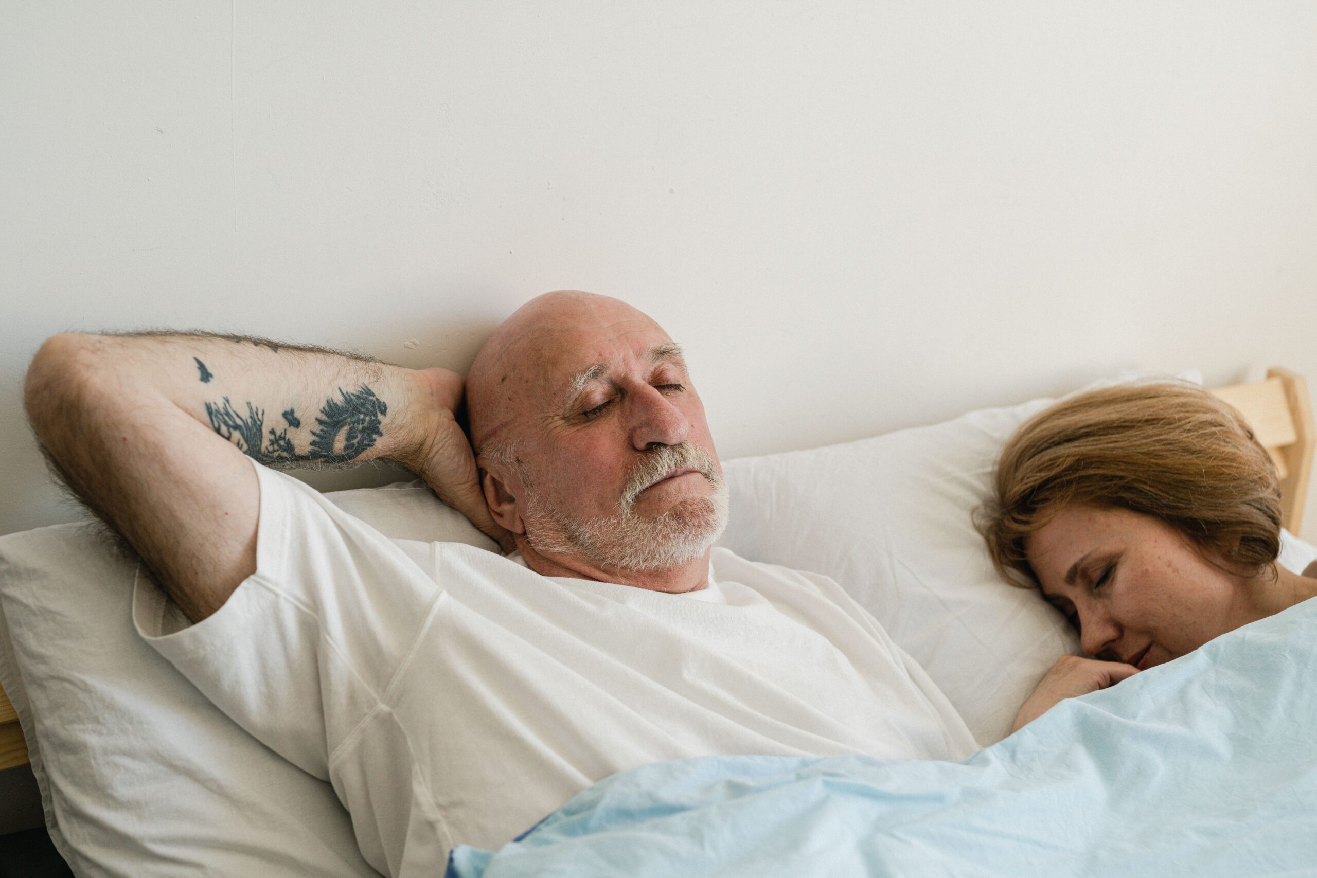 Older couple sleeping peacefully together in bed