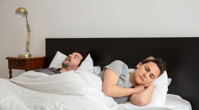 When Snoring Disrupts Your Relationship: How Couples Can Protect Sleep Without Blame One partner lying awake in bed while the other sleeps and snores