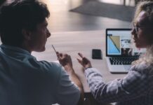 Two coworkers having a professional conversation in an office