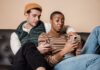 Couple sitting together on a sofa while each uses a smartphone