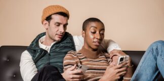 Couple sitting together on a sofa while each uses a smartphone