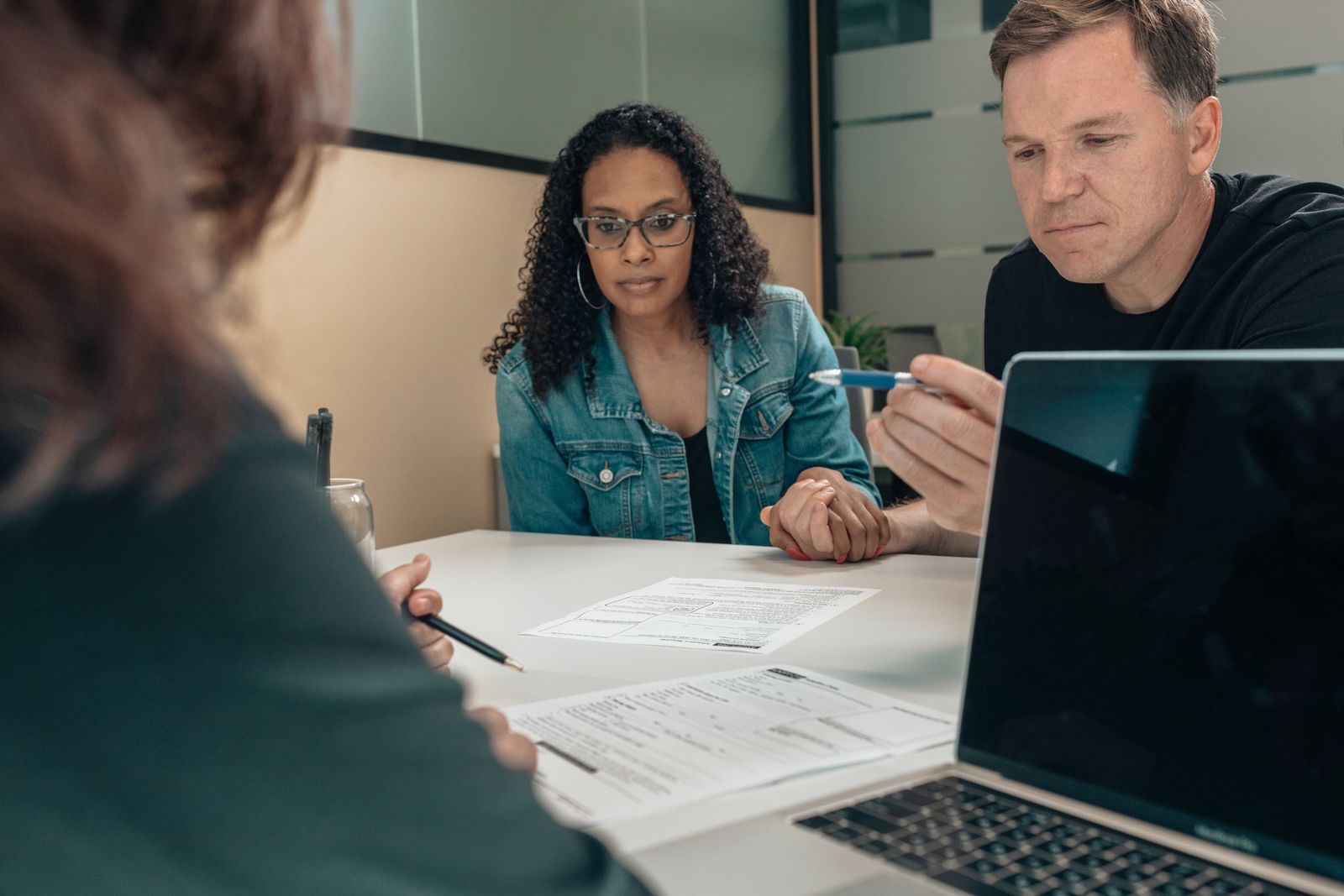 Couple listening to a professional explain documents during a joint consultation