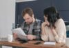 Engaged couple calmly reviewing documents together at home