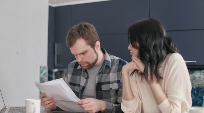 Engaged couple calmly reviewing documents together at home