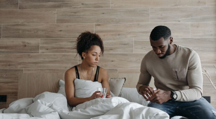 Spouse caregiver comforting an unwell partner at home