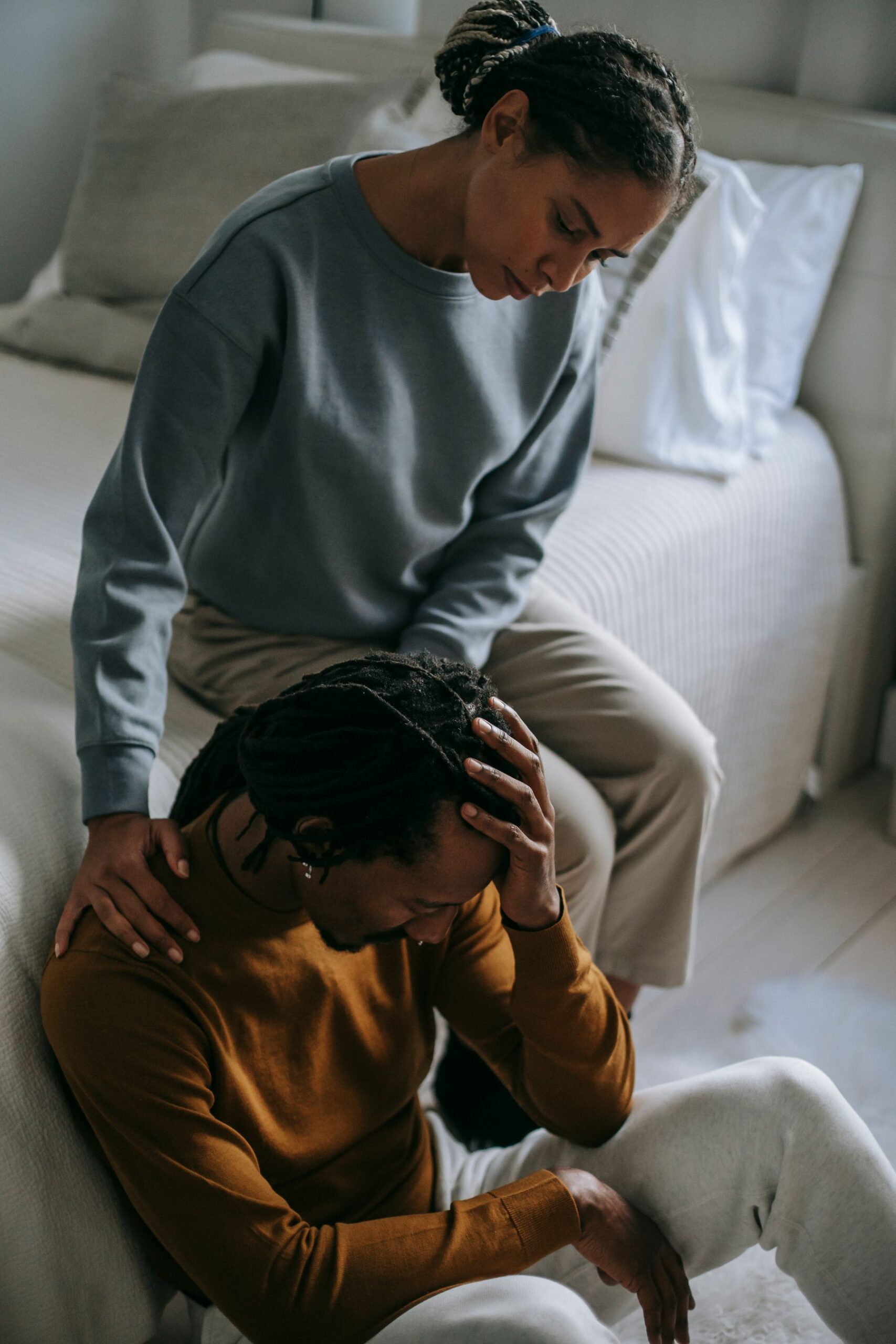 Partner offering quiet comfort to a grieving spouse at home