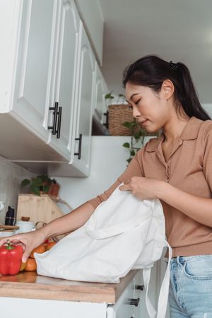 Person unpacking grocery bags and checking food already at home