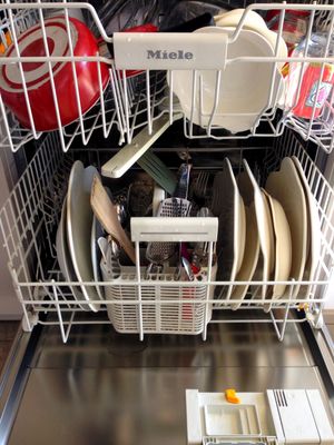 Open dishwasher filled with clean dishes ready to be unloaded