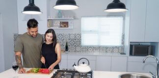 Couple cooking together while sharing responsibility for kitchen cleanup