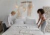 When Your Partner Never Changes the Bed Sheets: How to Share the Chore Without Nagging Couple changing bed sheets together in a shared bedroom