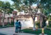 Couple outside their home discussing a garage closing routine