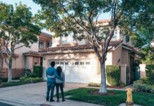 Couple outside their home discussing a garage closing routine