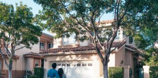 Couple outside their home discussing a garage closing routine