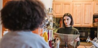 Couple discussing a paper towel restocking routine in their kitchen