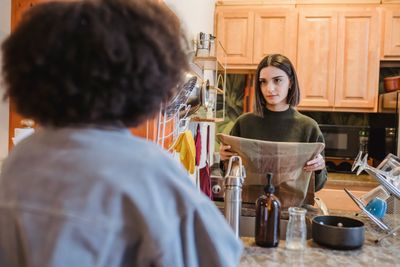 Couple discussing a paper towel restocking routine in their kitchen