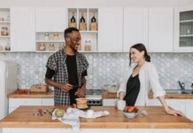 Couple discussing a refrigerator door closing routine in their kitchen