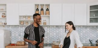 Couple discussing a refrigerator door closing routine in their kitchen
